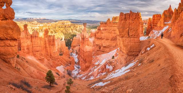 A view down into Bryce Canyon at Sunset Point with a ranger approaching on a hiking path
